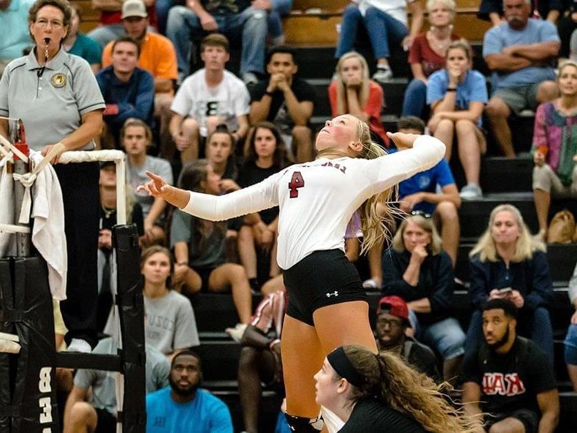 A volleyball player spikes the ball